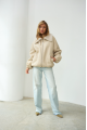 A short milk-colored bomber jacket made of natural sheepskin