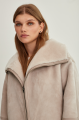 Women's sheepskin coat of beige color made of natural sheepskin