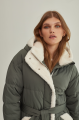 Stylish green women's down jacket with natural filler and sheepskin fur trim