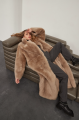 Long sheepskin coat made of natural cashmere lamb in brown color