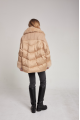 Women's down jacket of beige color with mink fur and decorative knitting and natural filler