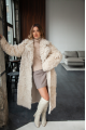 A long two-sided sheepskin coat made of milk-colored natural sheepskin