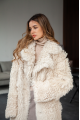 A long two-sided sheepskin coat made of milk-colored natural sheepskin