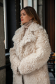 A long two-sided sheepskin coat made of milk-colored natural sheepskin