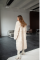 A long two-sided sheepskin coat made of milk-colored natural sheepskin