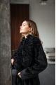 A long black sheepskin coat with a detachable collar