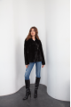 A classic sheepskin coat of black color made of natural sheepskin