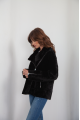 A classic sheepskin coat of black color made of natural sheepskin