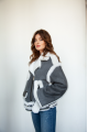 A stylish short sheepskin coat made of gray natural sheepskin with white fur