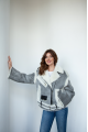 A stylish short leather jacket made of natural light gray sheepskin with white fur