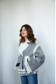 A stylish short leather jacket made of natural light gray sheepskin with white fur