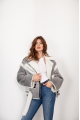 A stylish short leather jacket made of natural light gray sheepskin with white fur