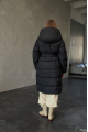 Women's long down jacket of black color with natural filling