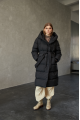 Women's long down jacket of black color with natural filling