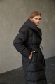 Women's long down jacket of black color with natural filling