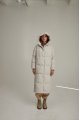 Women's long down jacket of white color with natural filler