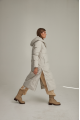 Women's long down jacket of white color with natural filler