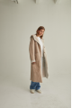 Women's long sheepskin coat of beige color made of natural sheepskin