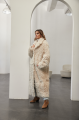 A long two-sided sheepskin coat made of milk-colored natural sheepskin