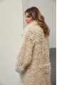 A long two-sided sheepskin coat made of milk-colored natural sheepskin