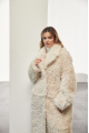 A long two-sided sheepskin coat made of milk-colored natural sheepskin