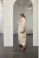 A long two-sided sheepskin coat made of milk-colored natural sheepskin