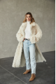 A long two-sided sheepskin coat made of milk-colored natural sheepskin