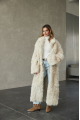 A long two-sided sheepskin coat made of milk-colored natural sheepskin