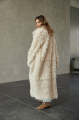 A long two-sided sheepskin coat made of milk-colored natural sheepskin